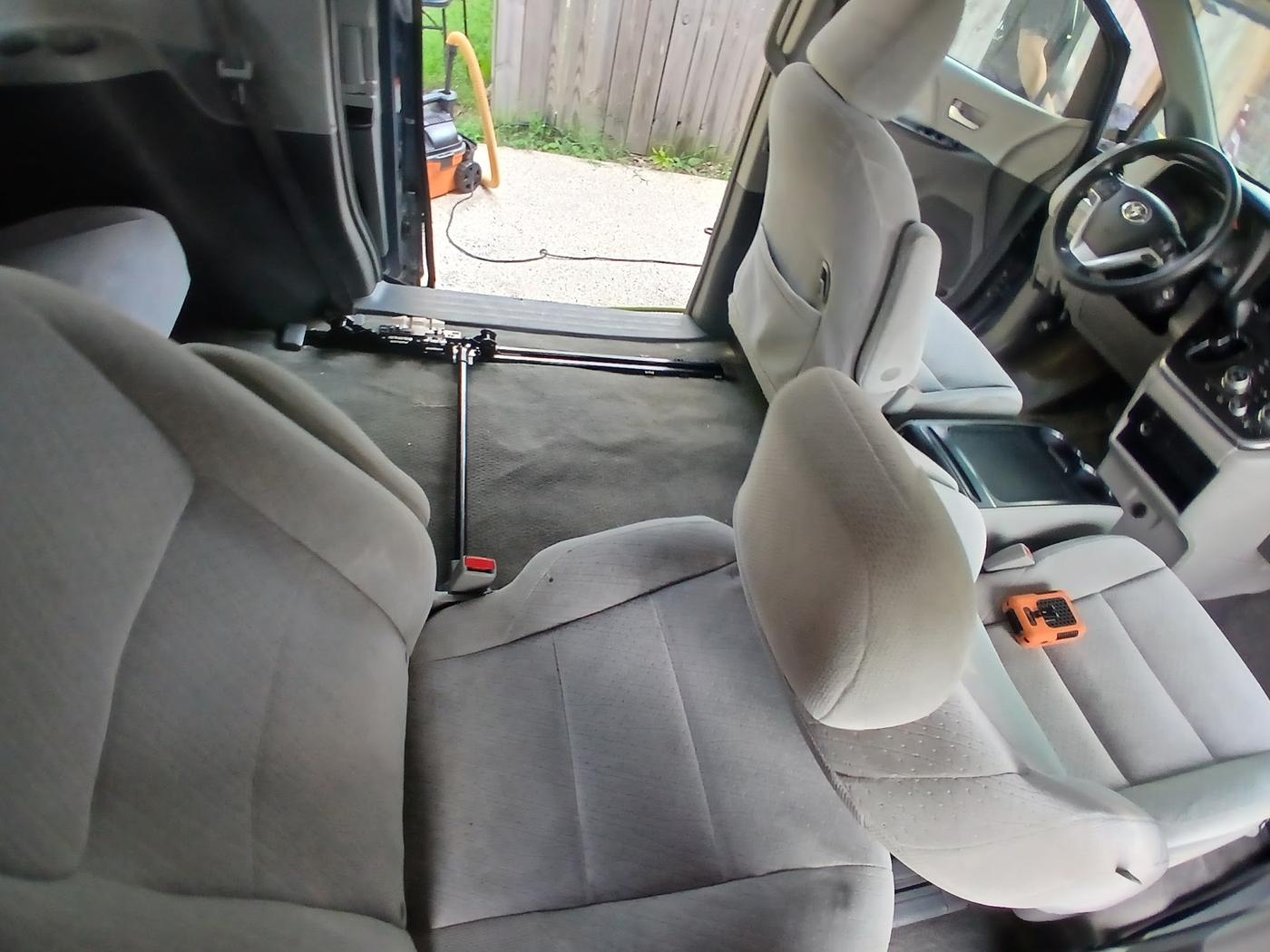 A car interior part way through an interior detail, seats and carpets being worked